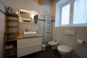a bathroom with a sink and a toilet and a mirror at Appartamento Bastione in Riva del Garda