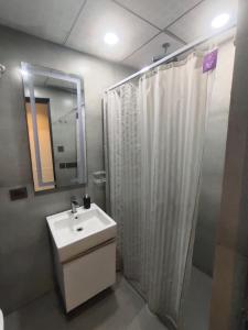 a bathroom with a sink and shower with a shower curtain at Landin2home studios in New Delhi +23 photos