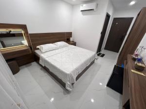 a small bedroom with a bed and a mirror at H99 Homestay in Ðông Bình (2)