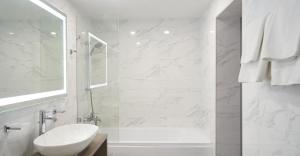 a white bathroom with a sink and a bath tub at Готель Дружба in Kyiv