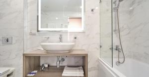 a white bathroom with a sink and a shower at Готель Дружба in Kyiv