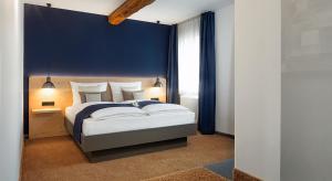 a bedroom with a large bed with a blue wall at Bischoffs Hotel in Bad Urach