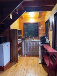 a kitchen with a sink and a large window at El Quetzalito Cabin in San Gerardo de Dota