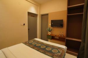 a hotel room with a bed and a flat screen tv at The Grand Sarayu in Mysore +34 photos