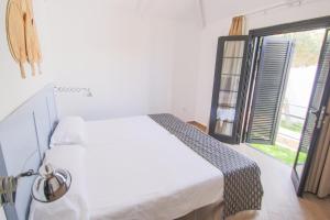 a bedroom with a white bed and a large window at Los Cardones Boutique Village in Playa de las Americas