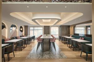 ein Esszimmer mit Tischen, Stühlen und Fenstern in der Unterkunft Hotel UKETAMO in Taipeh