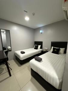 a hotel room with two beds and a desk at Royale City Hotel - 10 min from KLIA KLIA 2 Airport in Sepang