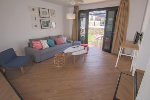 a living room with a couch and a table at Los Cardones Boutique Village in Playa de las Americas