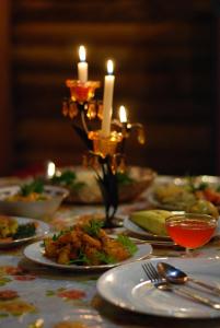 a table with plates of food and candles on it at Moon Plains Forest Log in Nuwara Eliya