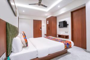 a bedroom with a bed and a flat screen tv at FabHotel Suruchi Homes in Vasai