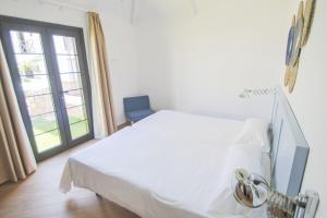 a white bed in a room with a window at Los Cardones Boutique Village in Playa de las Americas