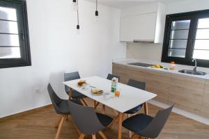 a kitchen with a white table and chairs in a room at Los Cardones Boutique Village in Playa de las Americas
