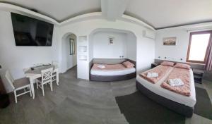 two beds in a room with a table and a desk at Guest House Harmony in Veliko Tŭrnovo +77 photos