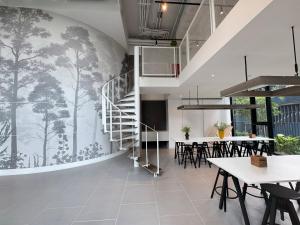 a dining room with a mural of trees on the wall at NUE District Rama 9 Condo in Bangkok