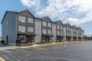 a row of apartment buildings in a parking lot at Amsterdam Inn & Suites, an Ascend Collection Hotel in Fredericton