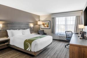 a hotel room with a large bed and a desk at Amsterdam Inn & Suites, an Ascend Collection Hotel in Fredericton
