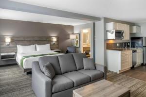 a hotel room with a bed and a couch at Amsterdam Inn & Suites, an Ascend Collection Hotel in Fredericton