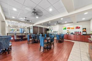 a dining room with blue chairs and a bar at Quality Inn Weeki Wachee - Spring Hill in Weeki Wachee