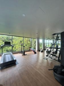 a gym with several exercise equipment in a room with windows at Hillside - Seashore Naiyang Beach in Phuket