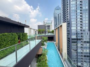 an apartment balcony with a swimming pool and tall buildings at NUE District Rama 9 Condo in Bangkok