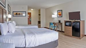 a hotel room with two beds and a flat screen tv at Quality Inn Milan-Sandusky in Milan