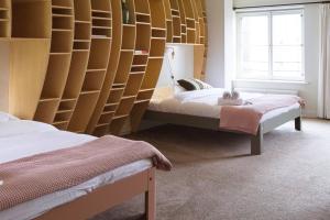 a bedroom with two beds and a wall of shelves at Bird Deventer in Deventer +15 photos