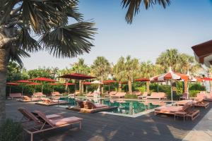 a resort pool with lounge chairs and umbrellas at Banyan Tree Dubai at Bluewaters in Dubai