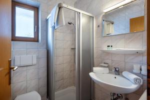 a bathroom with a sink and a toilet and a shower at Gästehaus Wildauer in Ebbs +11 photos