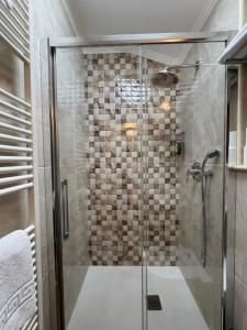 a shower with a glass door in a bathroom at Hotel Grahor Depandance in Sežana