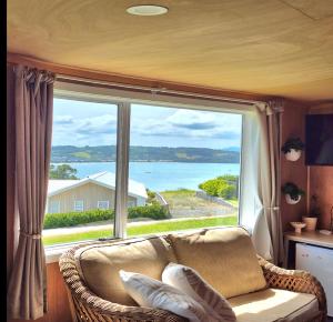 a living room with a couch and a large window at Tide and Tranquility - Guest Studio in Snells Beach
