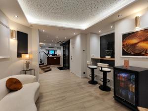 a living room with a couch and stools at 55 Hôtel Montparnasse in Paris