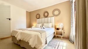 a bedroom with a large bed with two clocks on the wall at LoerieRoep Estate - Mountainview Selfcatering Accommodation Nelspruit in Nelspruit +117 photos