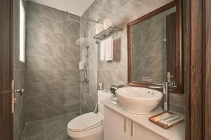 a bathroom with a sink and a toilet and a mirror at Hill Side Town Hotel DaLat in Da Lat +30 photos