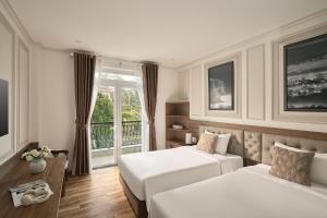 a hotel room with two beds and a balcony at Hill Side Town Hotel DaLat in Da Lat
