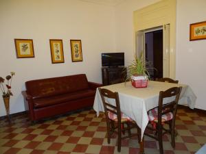 een woonkamer met een tafel en een bank bij Palazzo Iargia in Canicattini Bagni