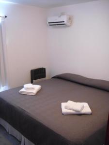 ein Zimmer mit einem Bett mit zwei Handtüchern darauf in der Unterkunft Nec Apart Hotel in Las Perdices