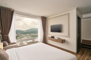 a hotel room with a bed and a large window at Hill Side Town Hotel DaLat in Da Lat
