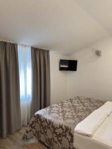 a bedroom with a bed and a window at Hotel Grahor Depandance in Sežana