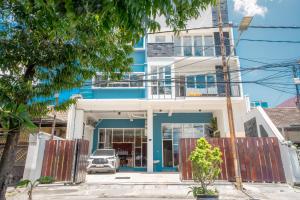 a blue building with a car parked in front of it at Hotel Pratisarawirya by The Loka in Surabaya