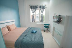a bedroom with a bed and a window and a television at Hotel Pratisarawirya by The Loka in Surabaya