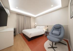 a hotel room with a bed and a chair at No 25 Iksan Station Branch in Iksan