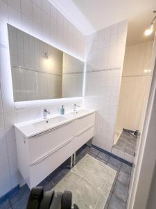 a white bathroom with a sink and a mirror at L'Escale St Nicolas in Hennebont