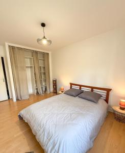 a bedroom with a large white bed with two pillows at L'Escale St Nicolas in Hennebont