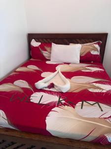 a bed with a red bedspread with a woman on it at Yakamoz Zanzibar in Zanzibar City