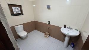 a small bathroom with a toilet and a sink at Elite Villa Raipur - Luxury Homestay in Raipur +28 photos