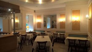 a dining room with tables and chairs in a restaurant at Central Hotel in Narva