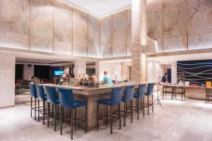 a lobby with a bar with blue bar stools at The Charm Resort Phuket in Patong Beach