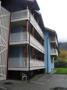 een gebouw met witte balkons en een bankje op een parkeerplaats bij Residence Vittoria in Pinzolo