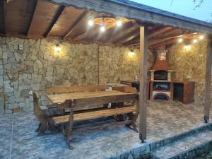 a patio with a wooden bench and a fireplace at къща за гости При Приятели in Nesebar