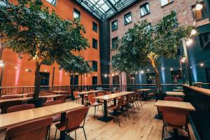 a restaurant with tables and chairs and trees at Clarion Hotel Mestari in Helsinki